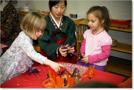 2 kindergarten girls working with japanese woman