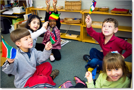 happy montessori kindergartners waving flags