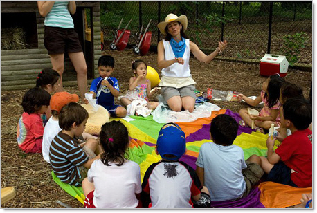 preschoolers sitting on colorful blanket during summer camp